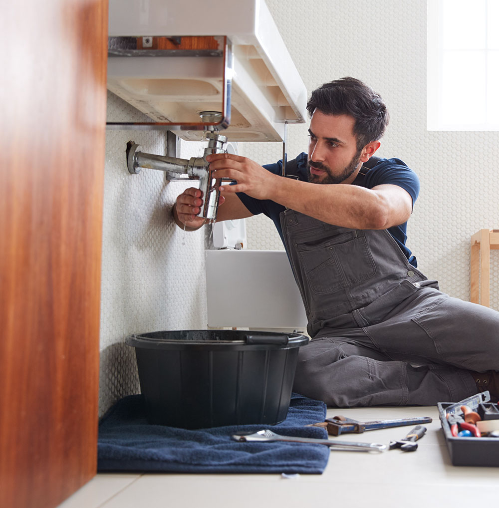 Professional handyman multitasking with tools wearing Trifecta uniform
